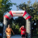 Man and woman running across finish line
