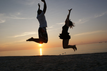 Two people jumping on a sunset beach - Image courtesy of Flickr user Click E